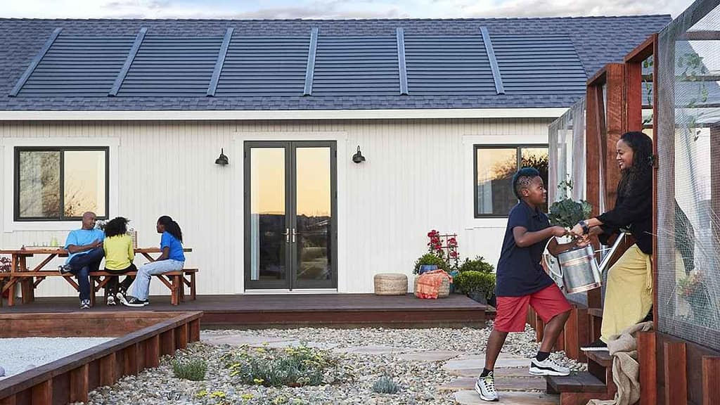 A Family outside their home with Gaf Tiberline Solar Shingles on the roof behind them