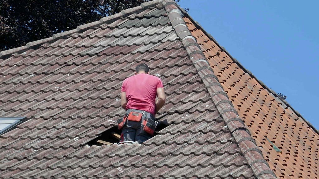 person repairing a damaged roof 