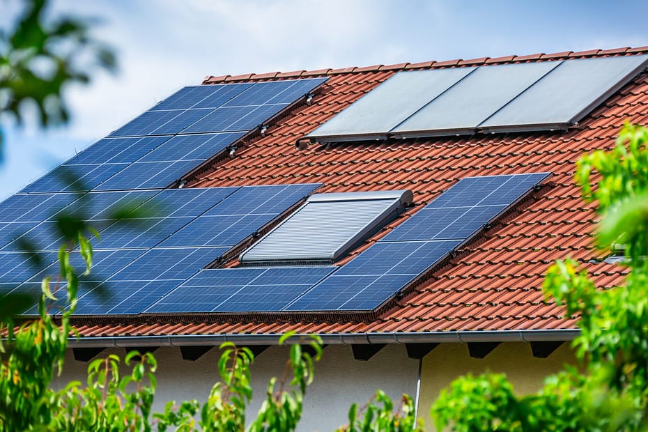 Technician installing solar panels on an older residential roof