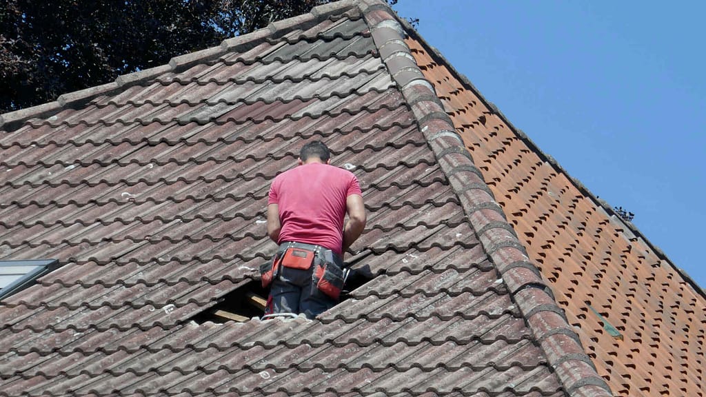 person repairing a damaged roof