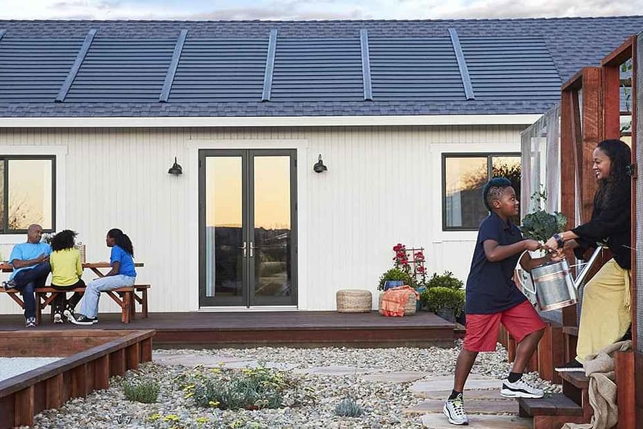 A Family outside their home with Gaf Tiberline Solar Shingles on the roof behind them